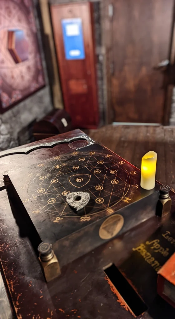 ouji board with a triangle element. In the background our kiosk system in paniq escape room atlanta
